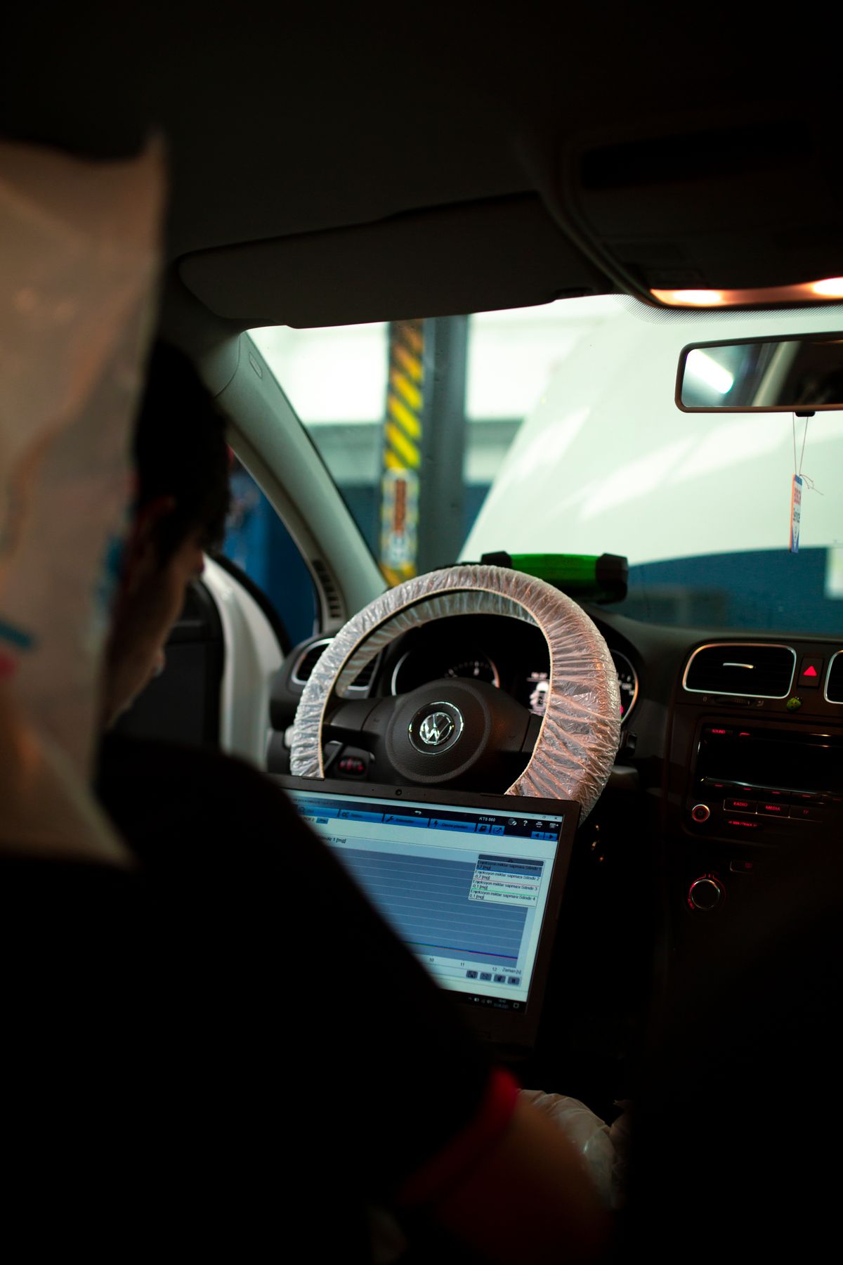 Automotive technician using a laptop to diagnose a vehicle